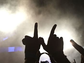 Low angle view of silhouette hand against sky