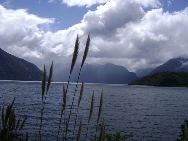 water, mountain, sky, tranquil scene, tranquility, scenics, beauty in nature, mountain range, lake, nature, cloud - sky, sea, cloud, idyllic, cloudy, plant, non-urban scene, outdoors, remote, calm