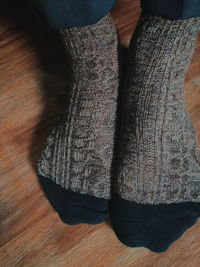 Low section of person wearing shoes on hardwood floor