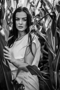 Portrait of young woman sitting on plants