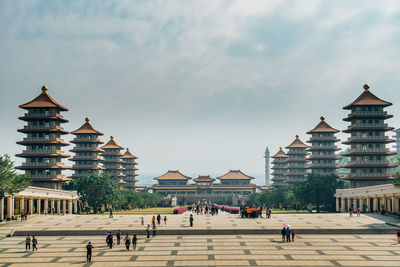 Group of people in front of building against sky