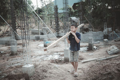 Full length portrait of boy standing against trees