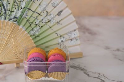 A few delicious macaroon, a famous french dessert with paper hand fan. 
