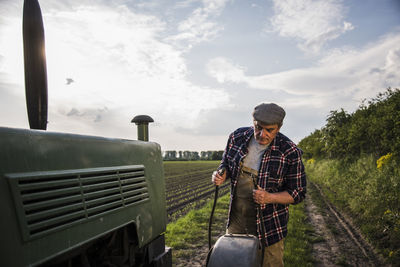 Farmer standing next to tractor at a field