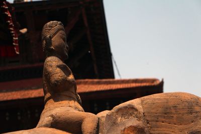 Low angle view of old statue against sky