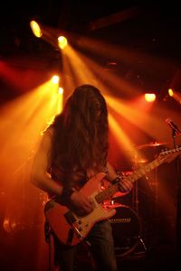 Woman playing guitar at music concert