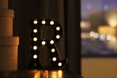 Close-up of illuminated letter r on table