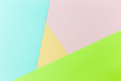 Low angle view of multi colored paper against blue background