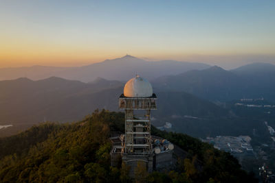 Built structure on mountain against sky during sunset