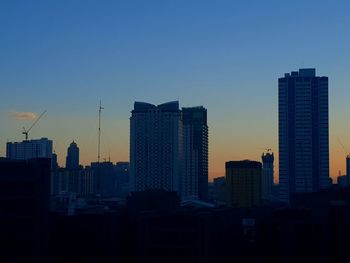 Modern buildings against sky during sunset