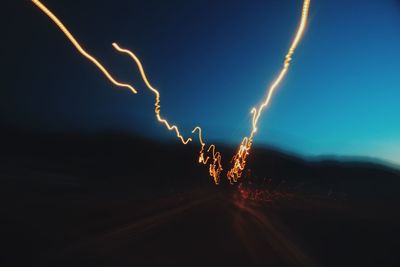 Lightning on beach against sky at night