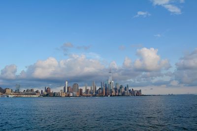 Buildings in city against cloudy sky