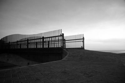 Footpath leading towards sea against sky