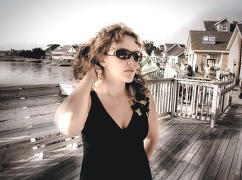 Beautiful woman standing on floorboard by river