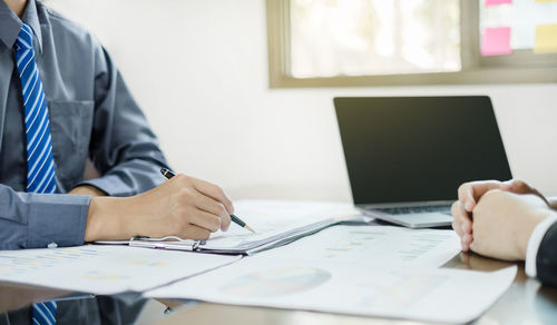 Midsection of business colleagues working at office