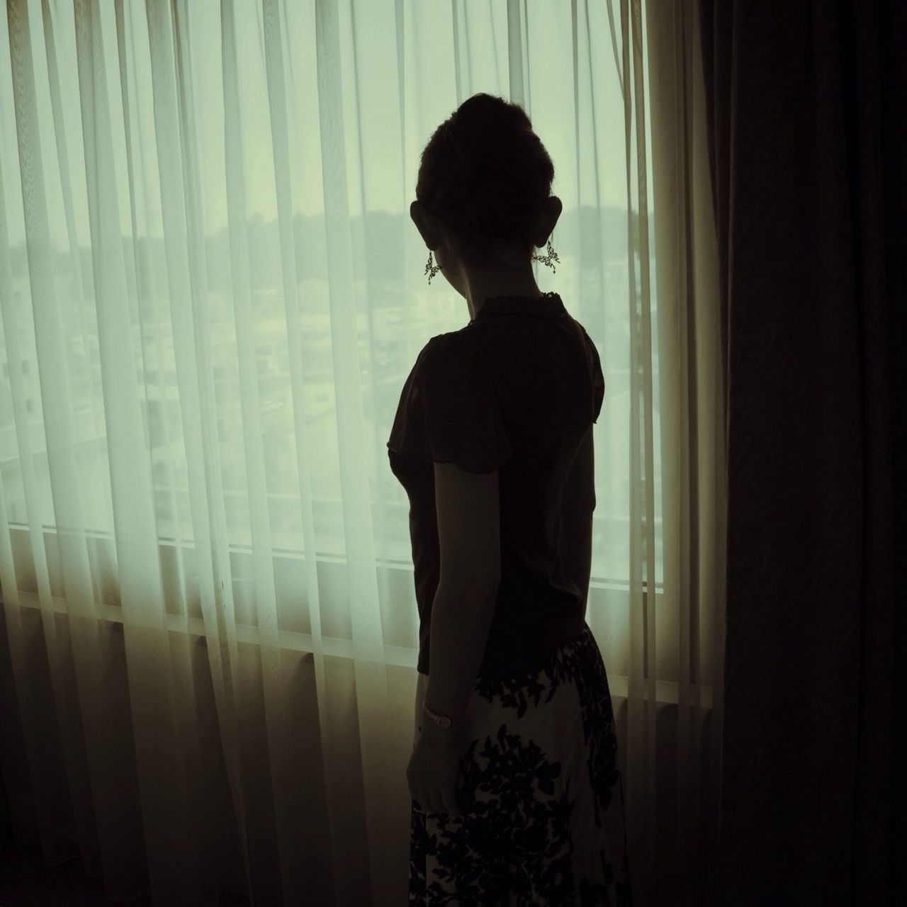 indoors, lifestyles, standing, window, rear view, curtain, person, home interior, young adult, young women, three quarter length, silhouette, leisure activity, full length, long hair, casual clothing, contemplation, side view