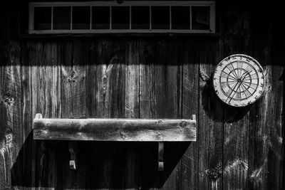 Close-up of wooden clock hanging on old door