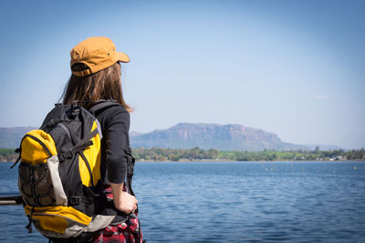 Rear view of woman in lake against sky