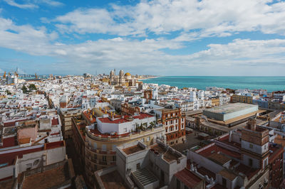 High angle view of townscape by sea against sky