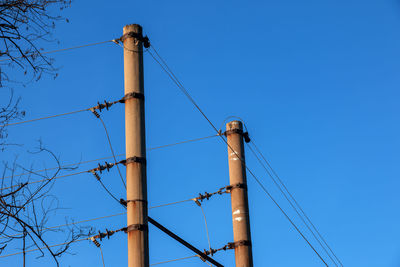 Electric pole with a linear wire against the blue sky close-up. power electric pole.
