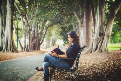 Man sitting on tree trunk in forest