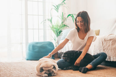 Portrait of woman playing with dogs at home