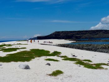 Scenic view of beach against blue sky