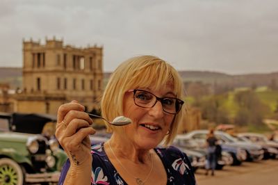 Portrait of woman having food in city