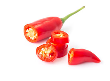 Close-up of red chili peppers over white background