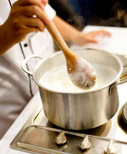 Midsection of person preparing food in kitchen