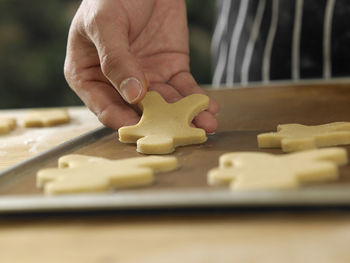 Midsection of chef preparing gingerbread cookies on table at kitchen