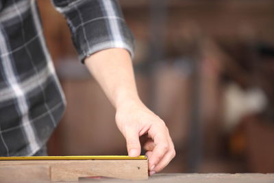 Midsection of carpenter working at workshop