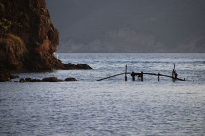 Scenic view of rocks in sea against sky
