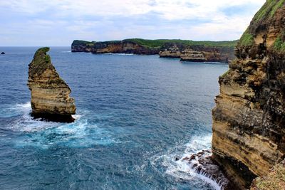 Rock formation in sea against sky