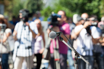 Close-up of microphone against journalists