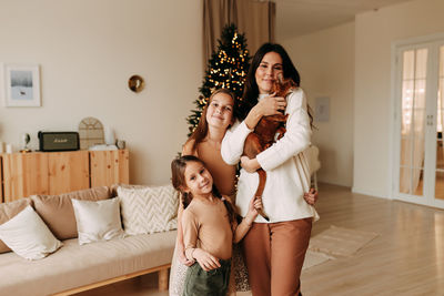 Full length of young woman sitting on bed at home