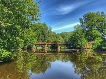Arch bridge over lake against sky