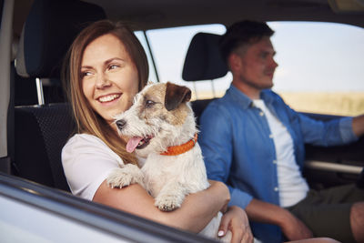 Couple with dog traveling in car