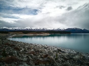 Scenic view of lake and snowcapped mountains against sky