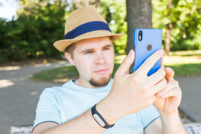 Portrait of man photographing with mobile phone