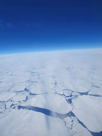 Scenic view of snow covered landscape against blue sky