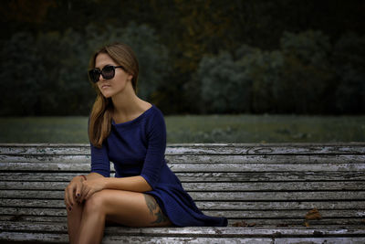 Woman wearing sunglasses sitting outdoors