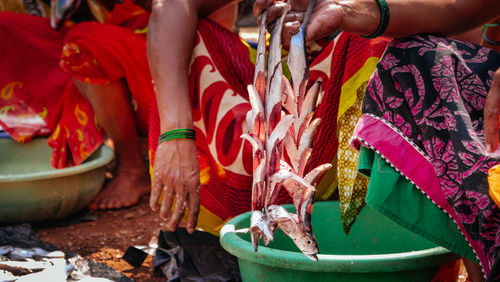 Low section of women selling fish in market