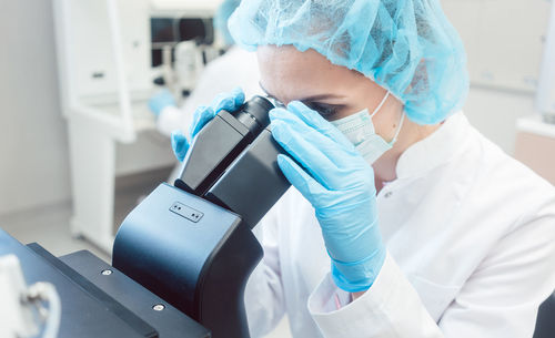 Woman scientist working on microscope in laboratory