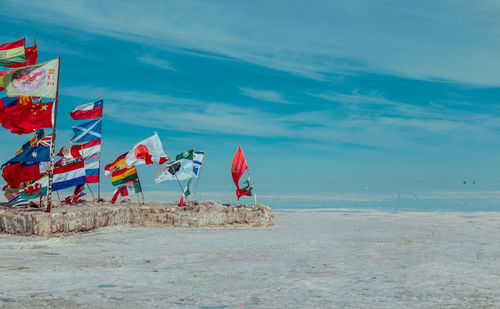 Flags on beach against sky