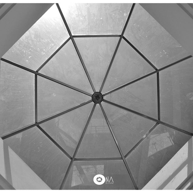 indoors, ceiling, pattern, architecture, low angle view, geometric shape, built structure, modern, design, circle, directly below, glass - material, shape, architectural feature, skylight, no people, full frame, backgrounds, illuminated, transparent