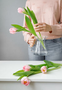 Midsection of woman holding flower