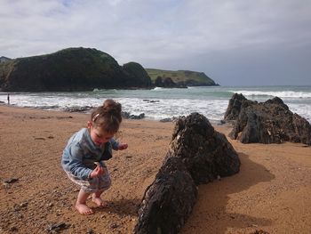 Little girl on beach find seashells 