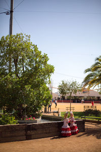 People sitting at park against clear sky