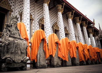 Orange fabrics on statues at temple